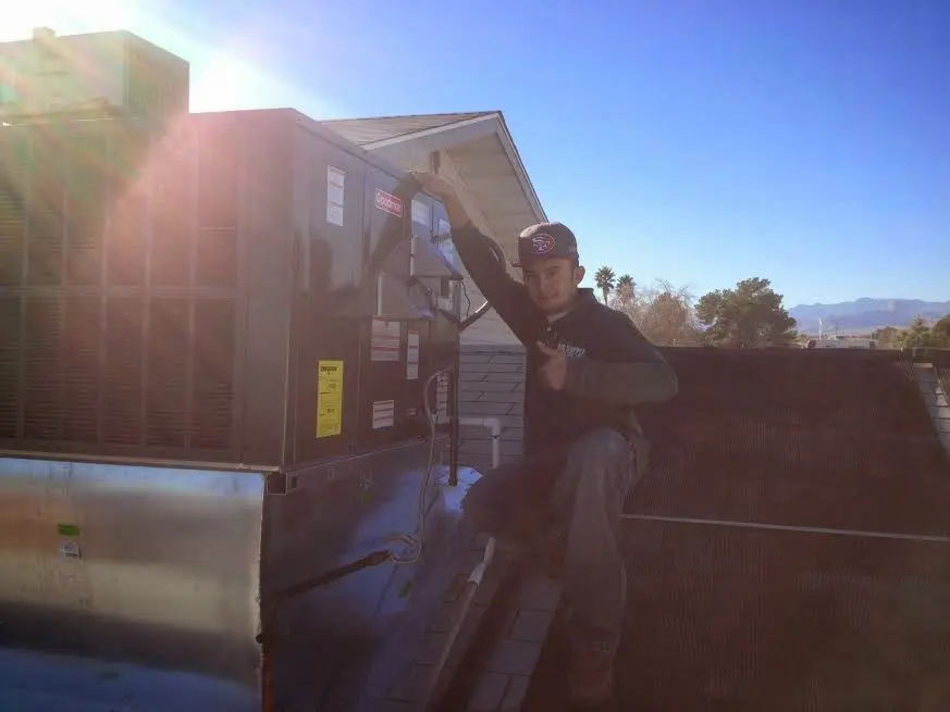 HVAC technician performing Air Duct Cleaning on a rooftop unit in Zionsville
